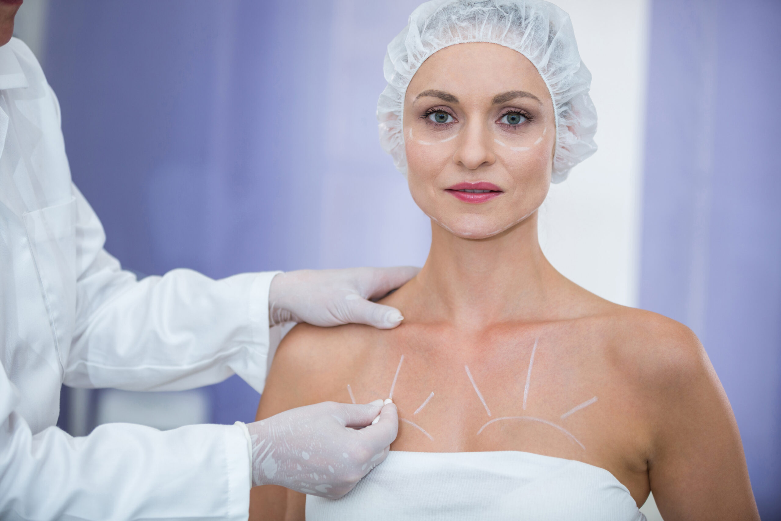 Portrait of doctor marking female patients body for breast surgery